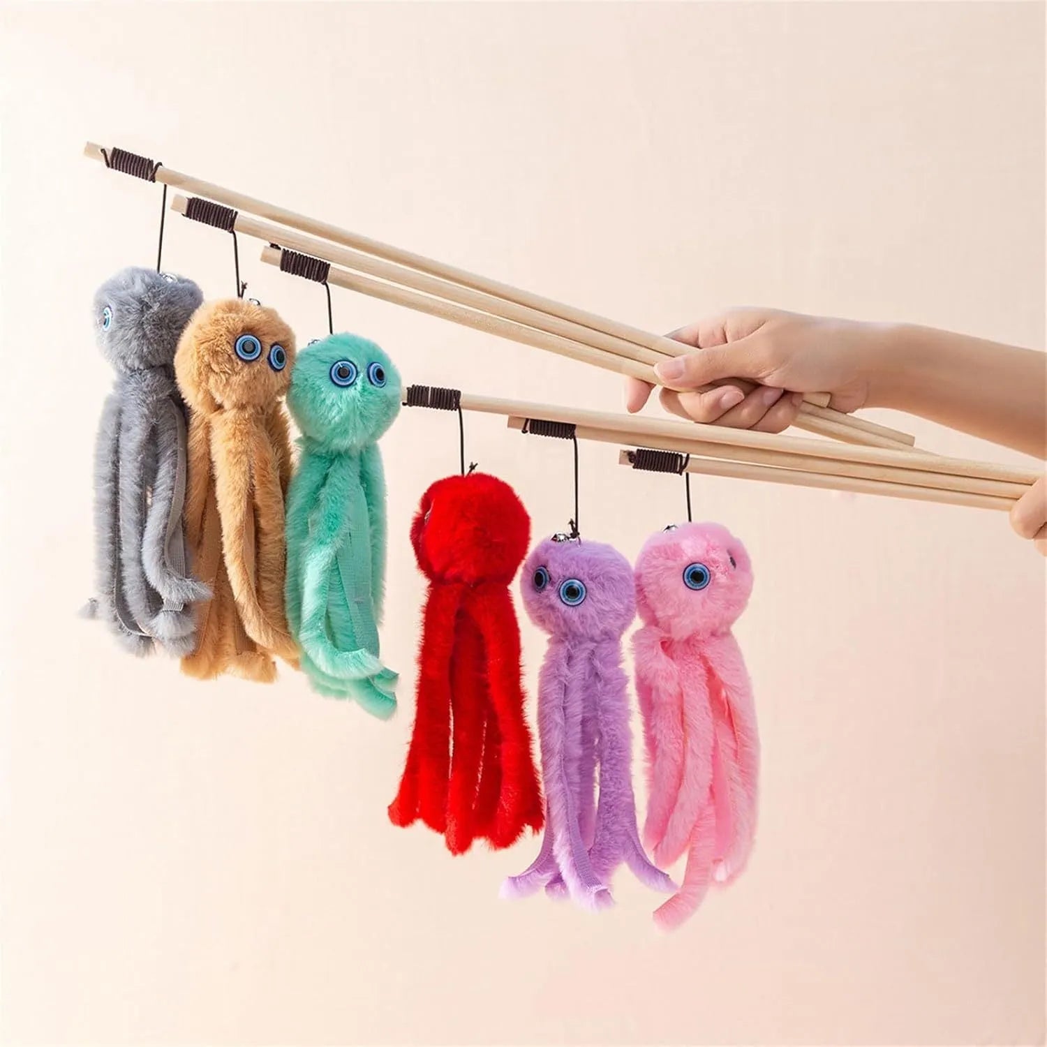 Grey furry octopus cat toy with eyes on a long stick for interactive indoor play with kittens.