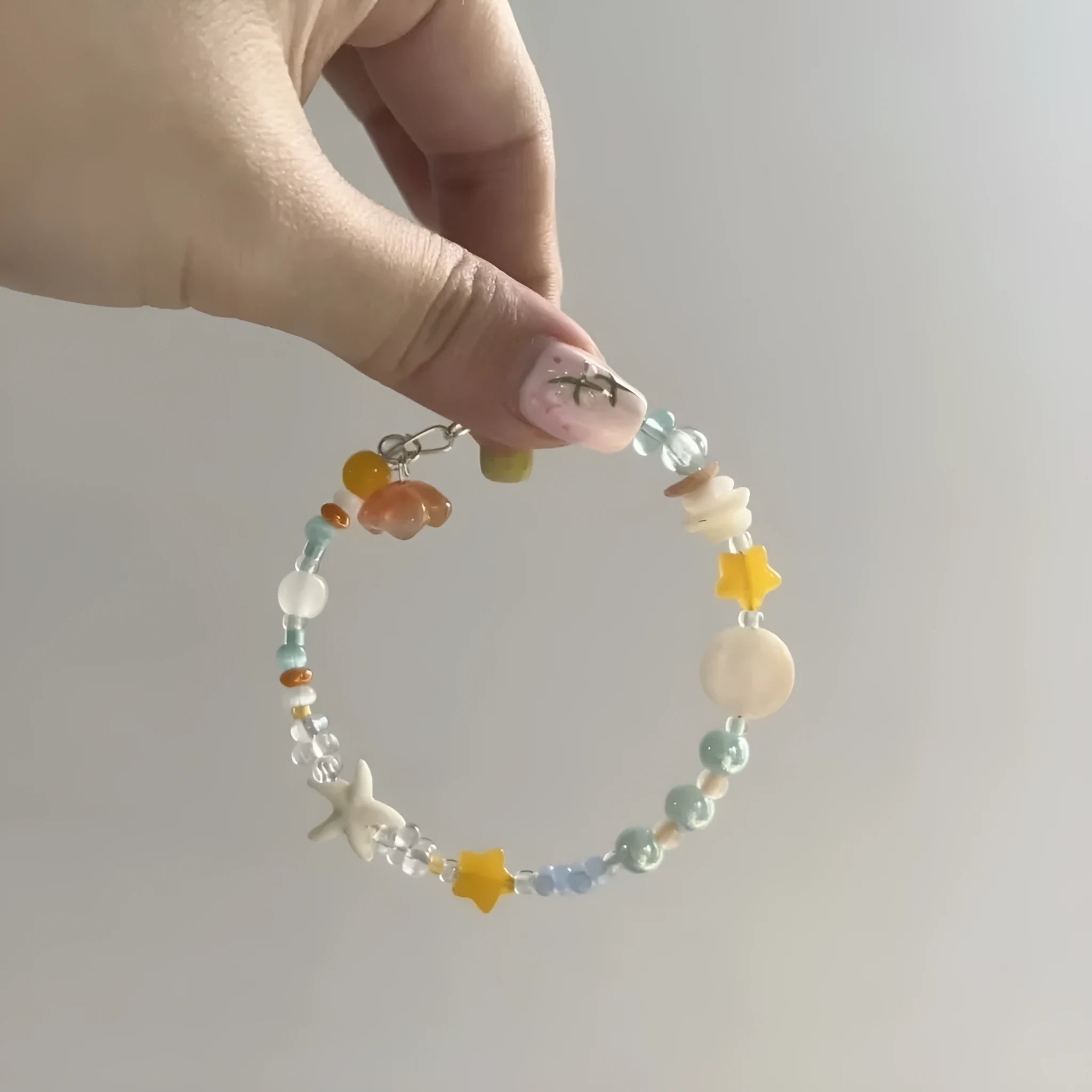 Orange seaside-inspired alloy bracelet with diamond charm and round elements showing water-soaked design aesthetic