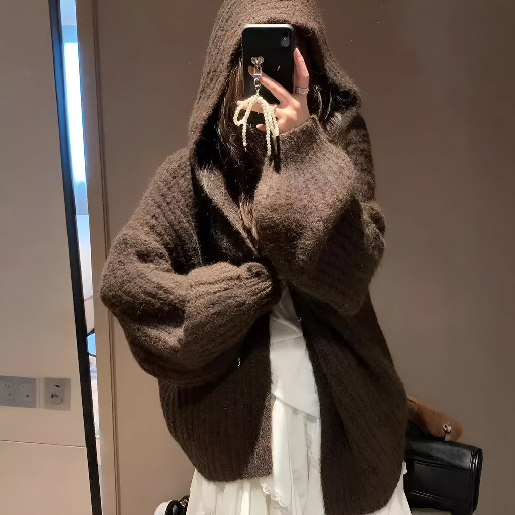 Woman wearing a loose-fit, chunky knit hooded cardigan in a macaron colour.