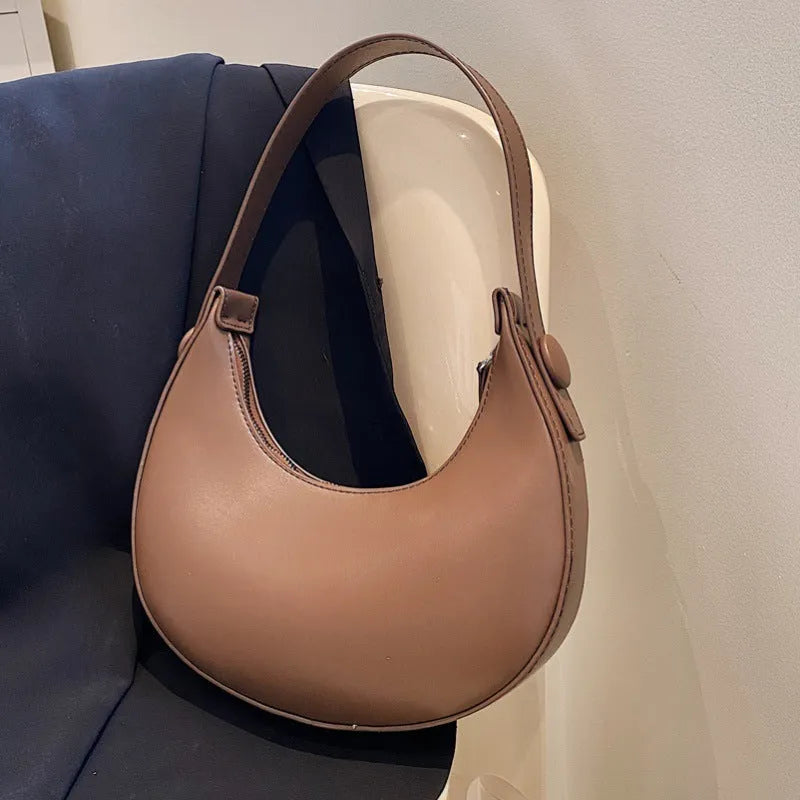 Women's retro-style PU shoulder bag in a dumpling shape, shown in one of four colours: black, cream yellow, brown, or white.