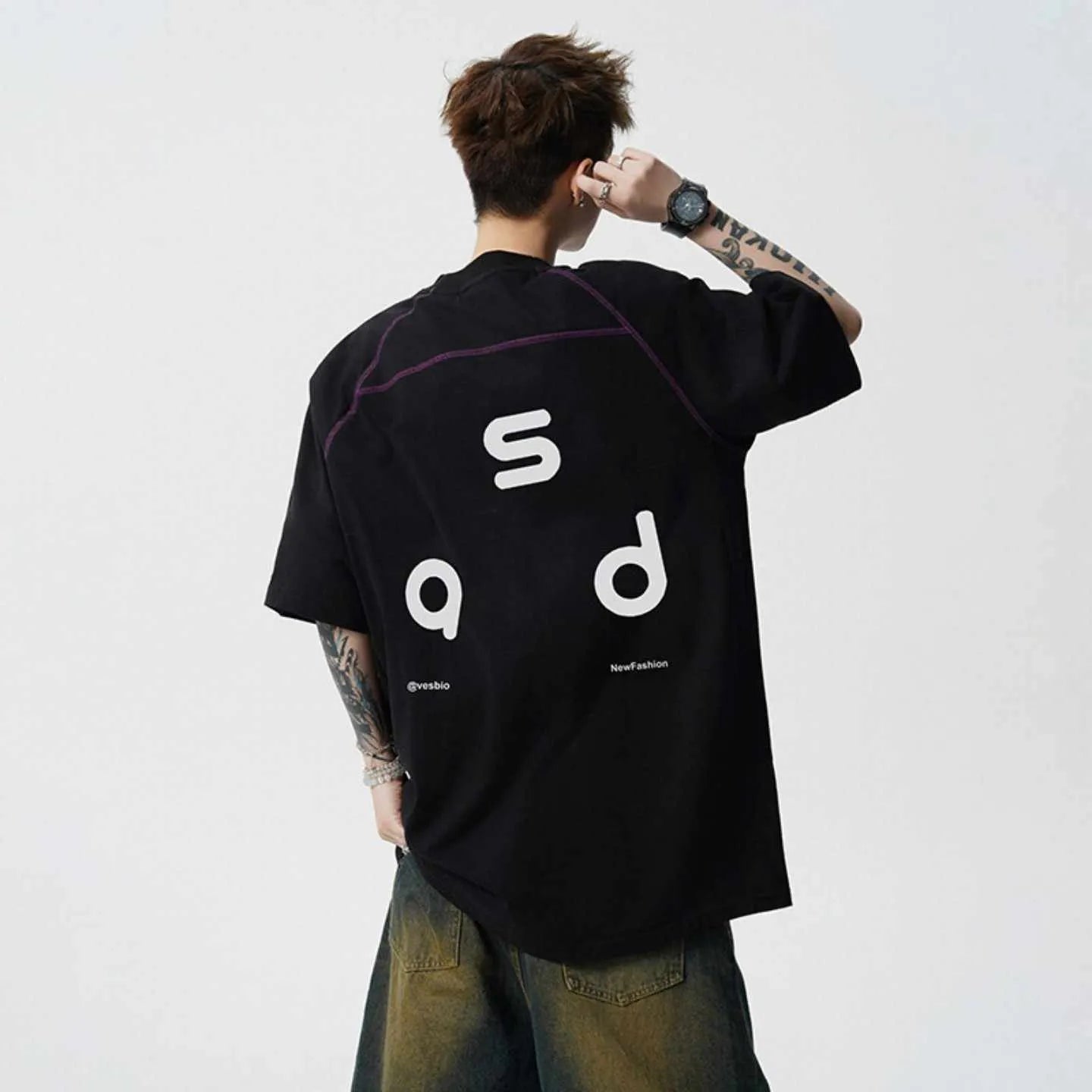 A loose-fitting black cotton t-shirt with letter print detail on the front, showing short sleeves and a round neck.