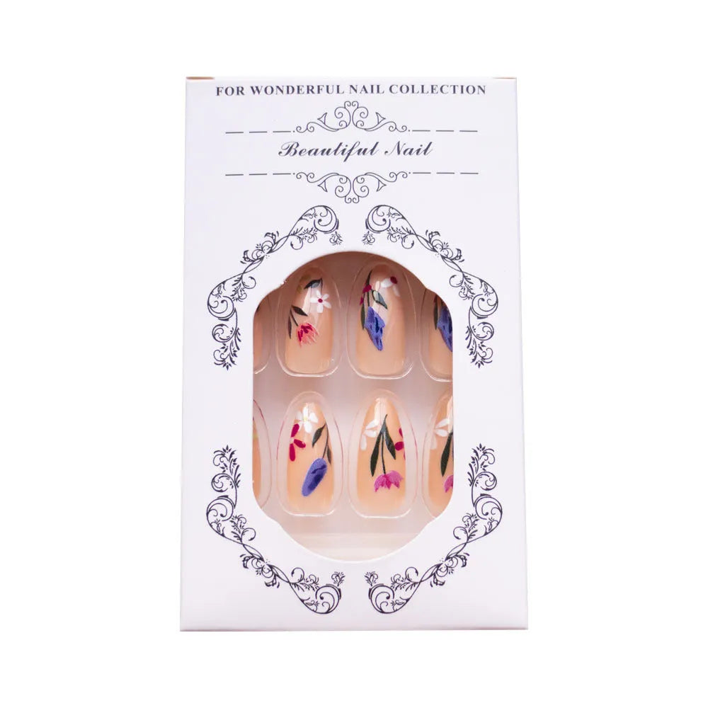 Almond-shaped false nails with detailed 3D pink rose and tulip floral designs on a solid colour base.