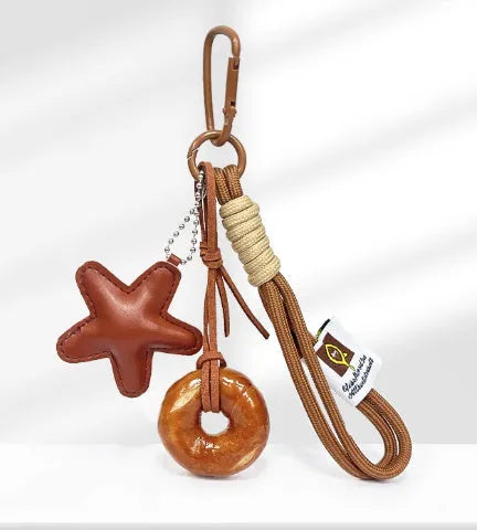 Handmade resin handbag pendant with soda bread designs including cartoon croissant and brown stars