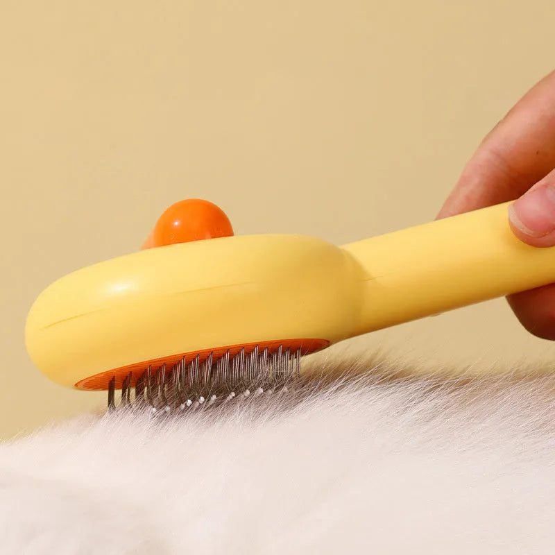 Small yellow duck-shaped comb for pet grooming with needle points and floating hair removal device