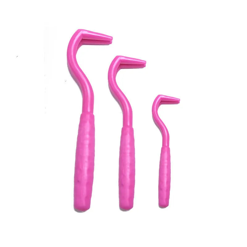 Three plastic tick removal hooks for dogs in assorted colours on a white background.