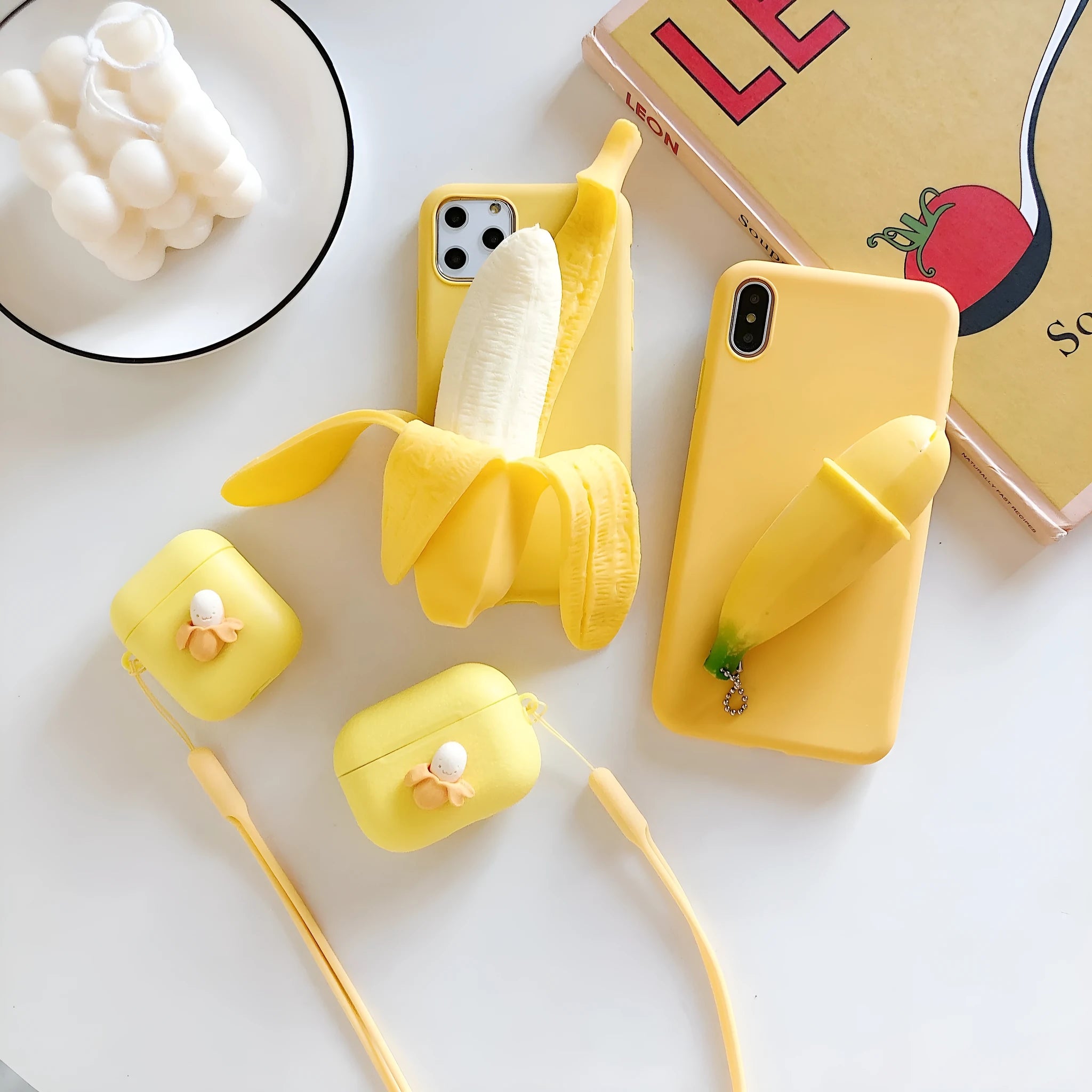 Yellow banana-coloured IMD back cover case for iPhone models 6 through 13 Pro Max on a table.