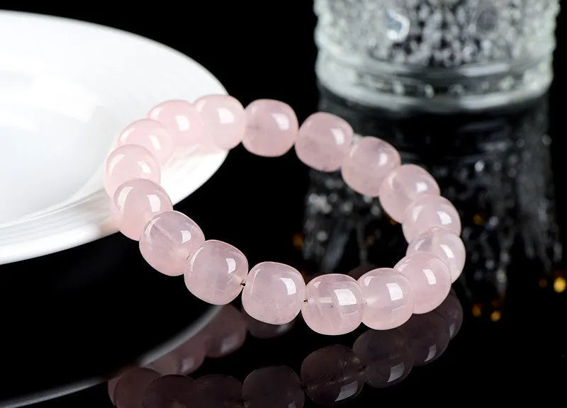 Pink crystal barrel bead bracelet with 11-12mm geometric beads on natural background