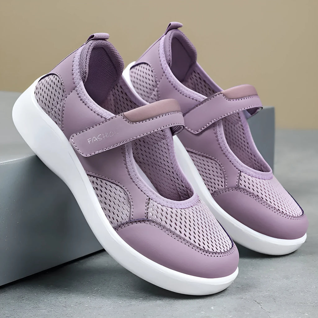 Women's low-top grey mesh sneakers with Velcro straps on a flat polyurethane sole.