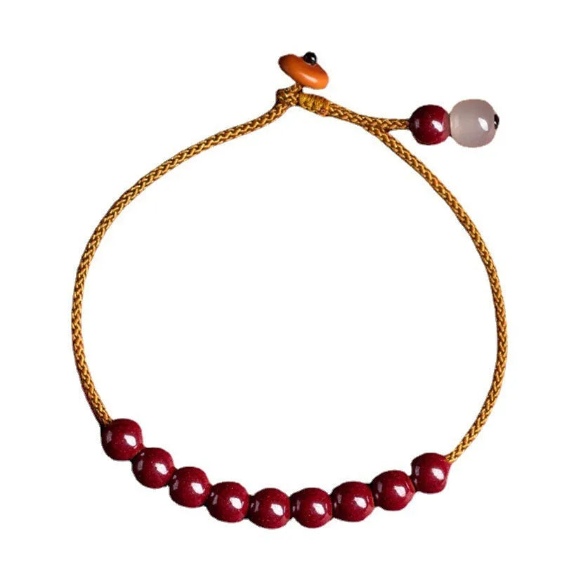 Hand-woven geometric bracelet made from raw Cinnabar and Hetian Jade ore on a wrist.