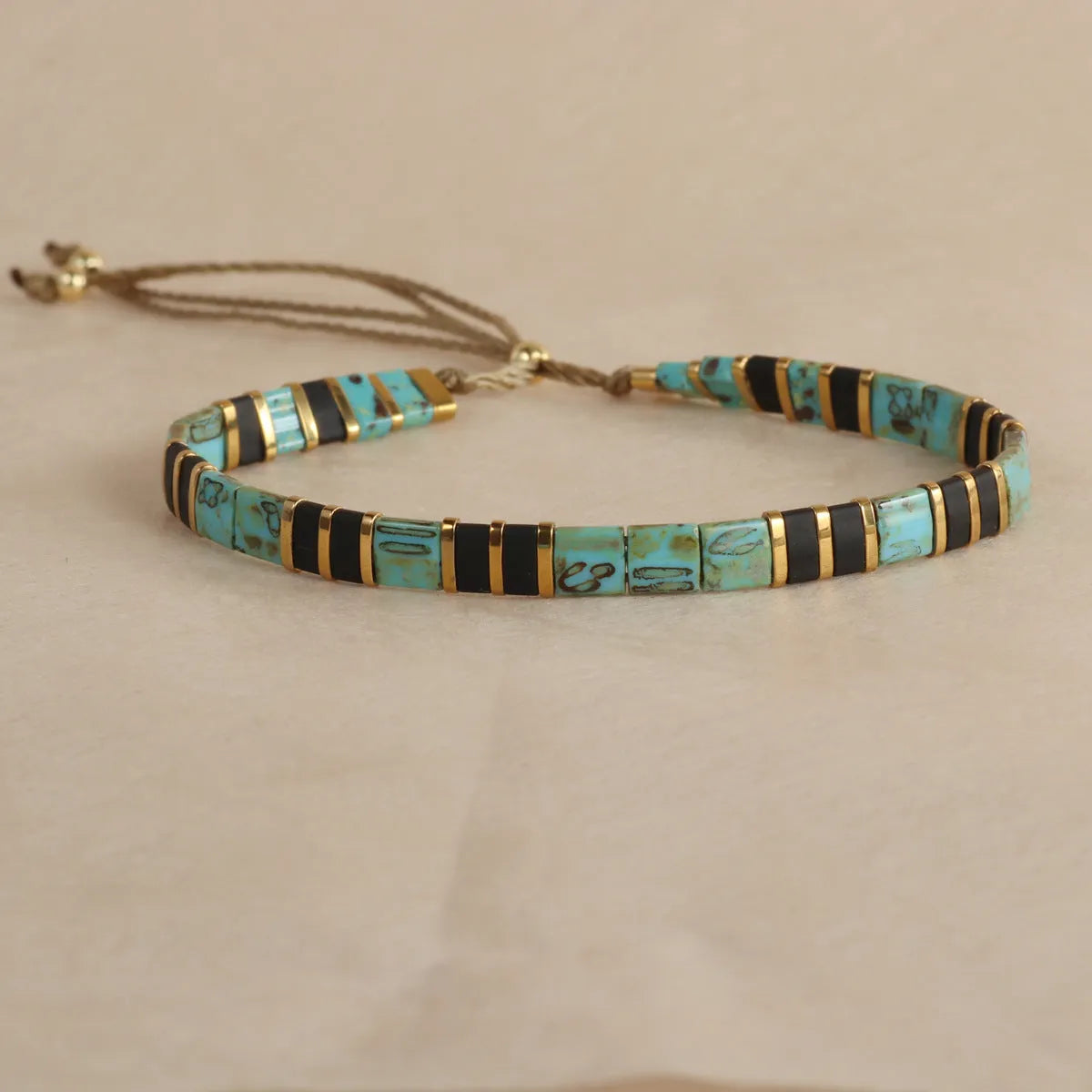 Geometric pull bead bracelet in milky white glass beads on a wrist.