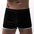 Men's solid colour boxer shorts in a cotton and nylon fabric blend, shown in black, on a mid-waist fit model.