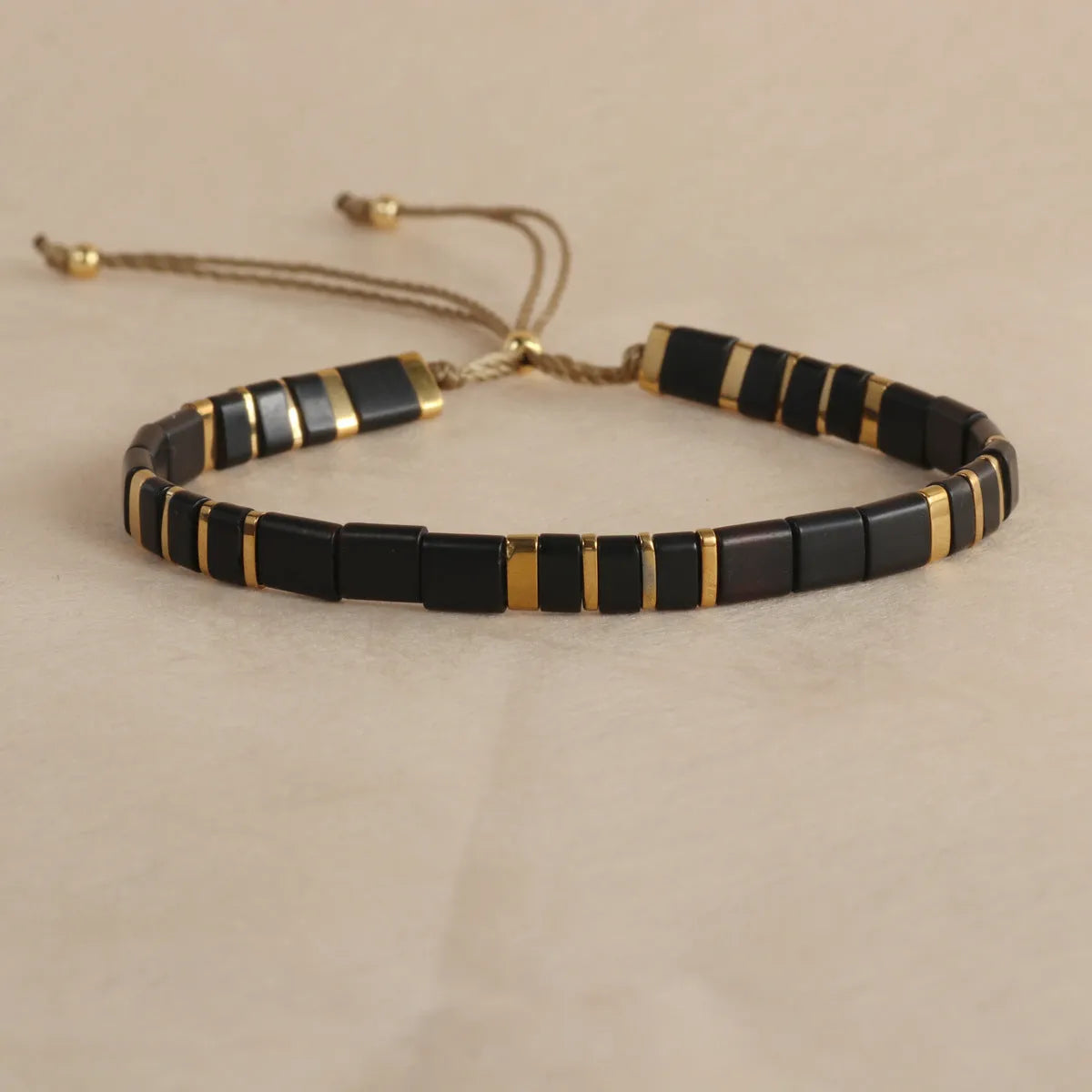 Geometric pull bead bracelet in milky white glass beads on a wrist.