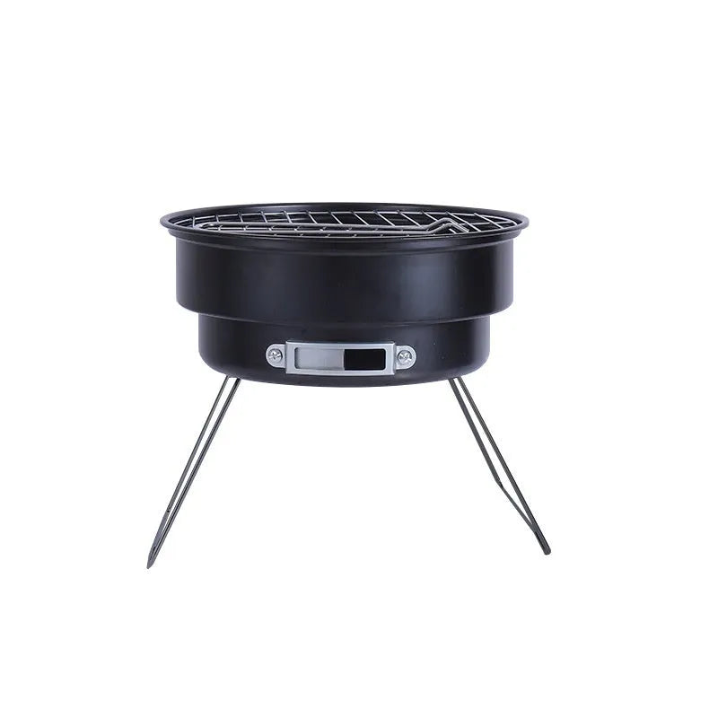 Small round metal camping stove with folding legs, mesh grill pan, charcoal clip, and carry bag.