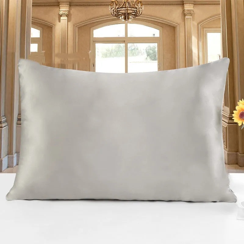 19 M double-sided silk pillowcase in apricot colour on a bed.