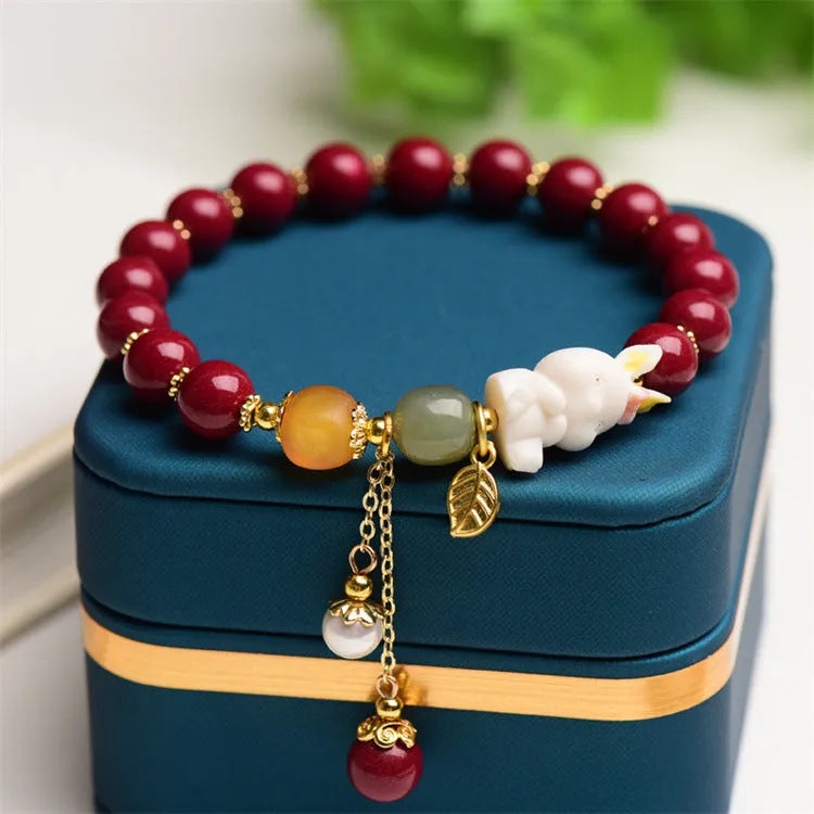 Natural red cinnabar bracelet for women featuring a carved rabbit design, shown in 8mm and 10mm width options.