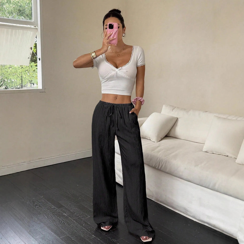 Women's black wide-leg trousers with lace-up waist trimming detail on mid-rise waist