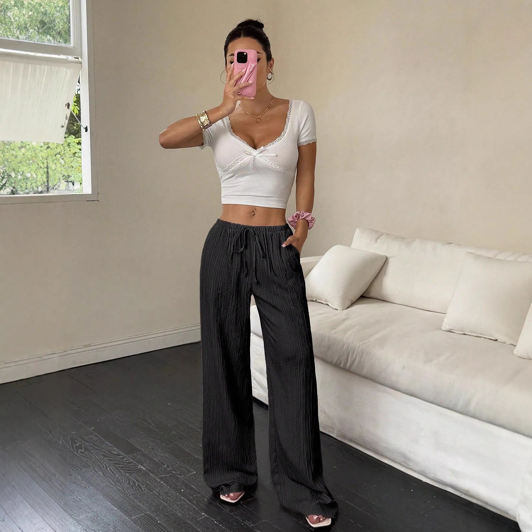 Women's black wide-leg trousers with lace-up waist trimming detail on mid-rise waist