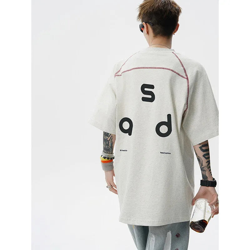 A loose-fitting black cotton t-shirt with letter print detail on the front, showing short sleeves and a round neck.