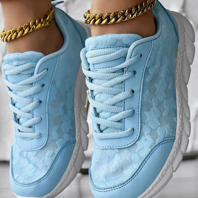 Women's white canvas running shoes with round toe and flat heel on a light background