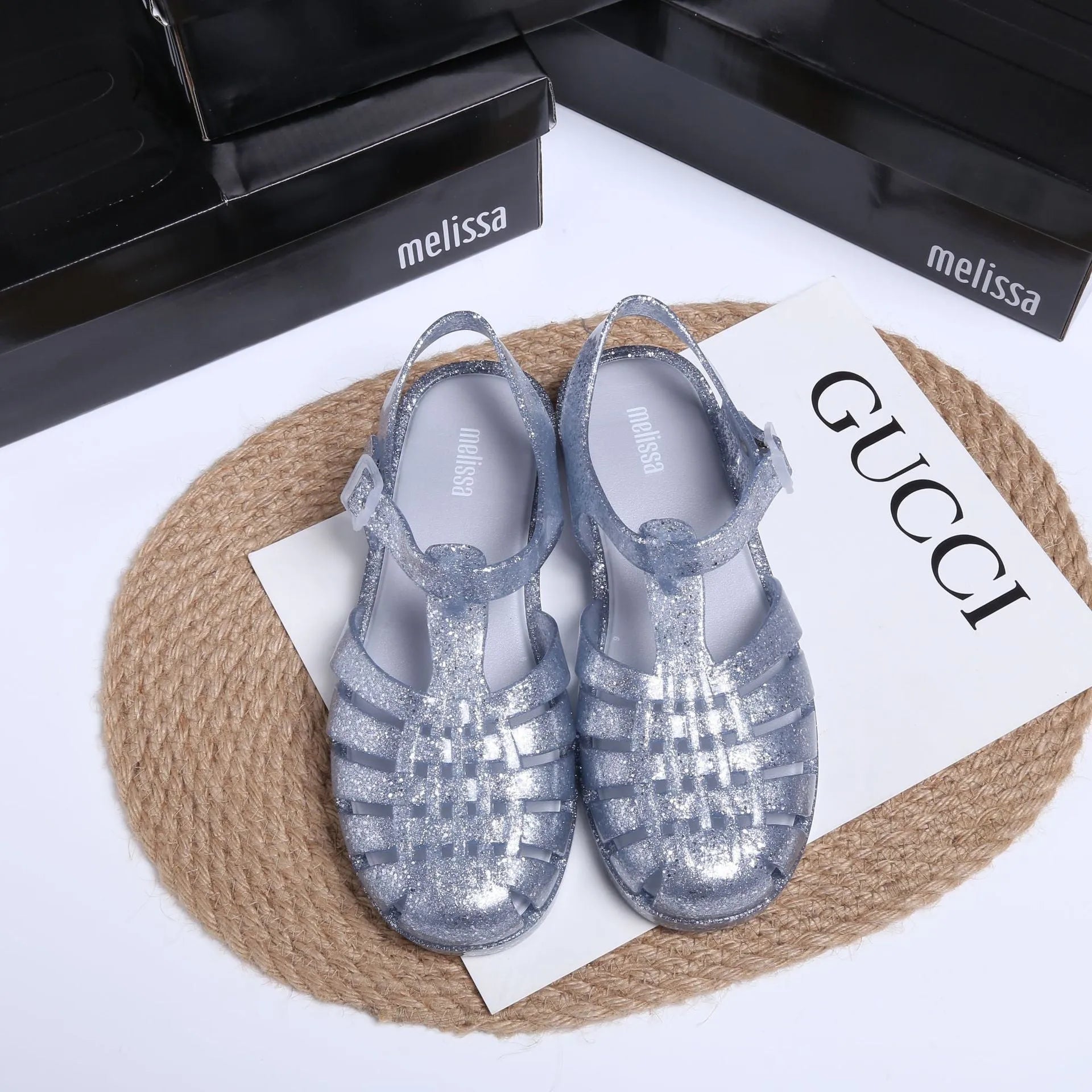 Black Roman-style sandals with buckle fastening and hollow-out design on low-top PVC upper