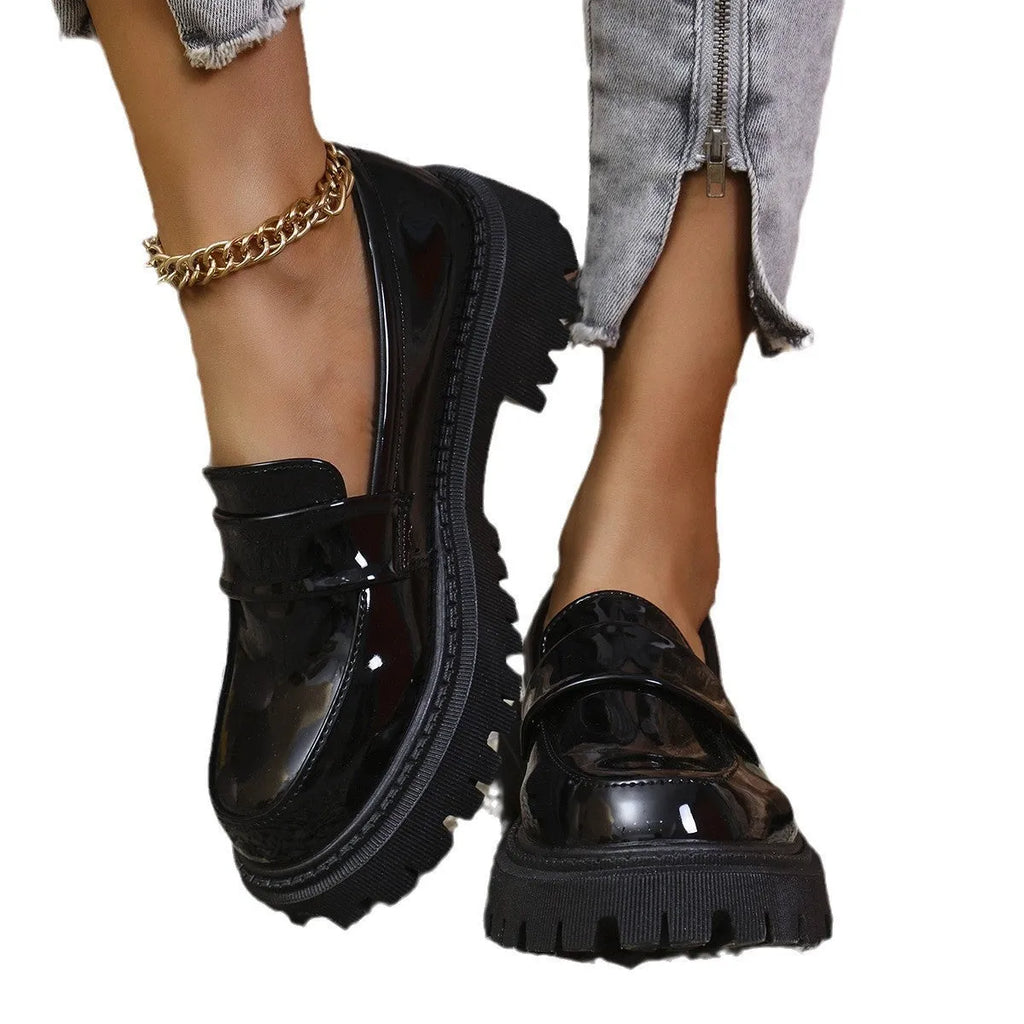 Women's black slip-on loafers with a chunky platform heel and rubber sole on a neutral background.
