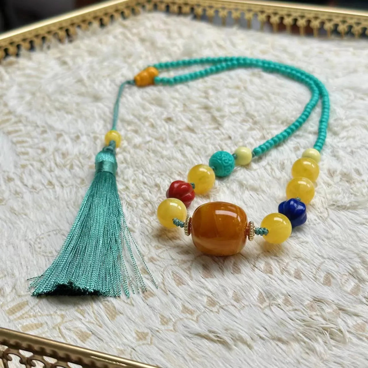 Turquoise lucky pendant necklace with hand-woven mesh flower design on a ball bead chain.