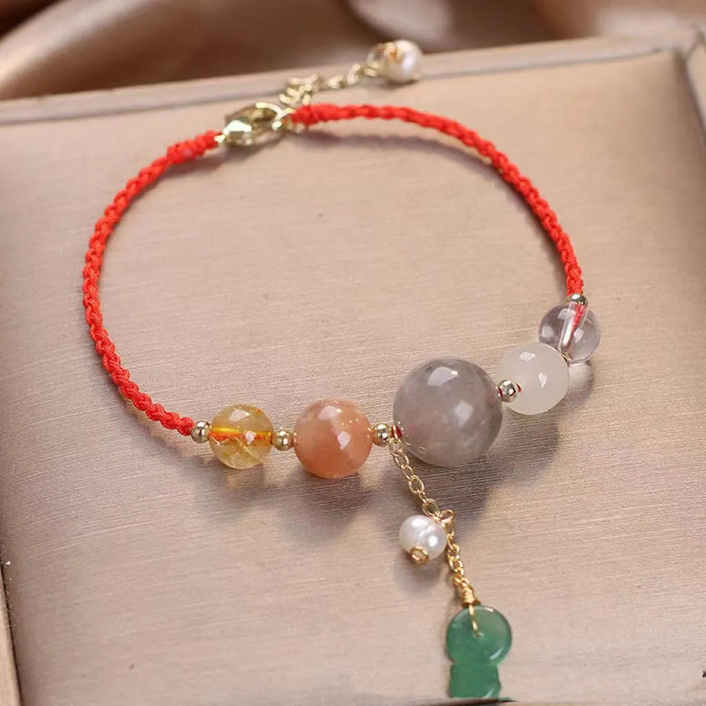 Women's hand-woven bracelet with peace buckle closure and crystal sequins in red, green, and blue colour options