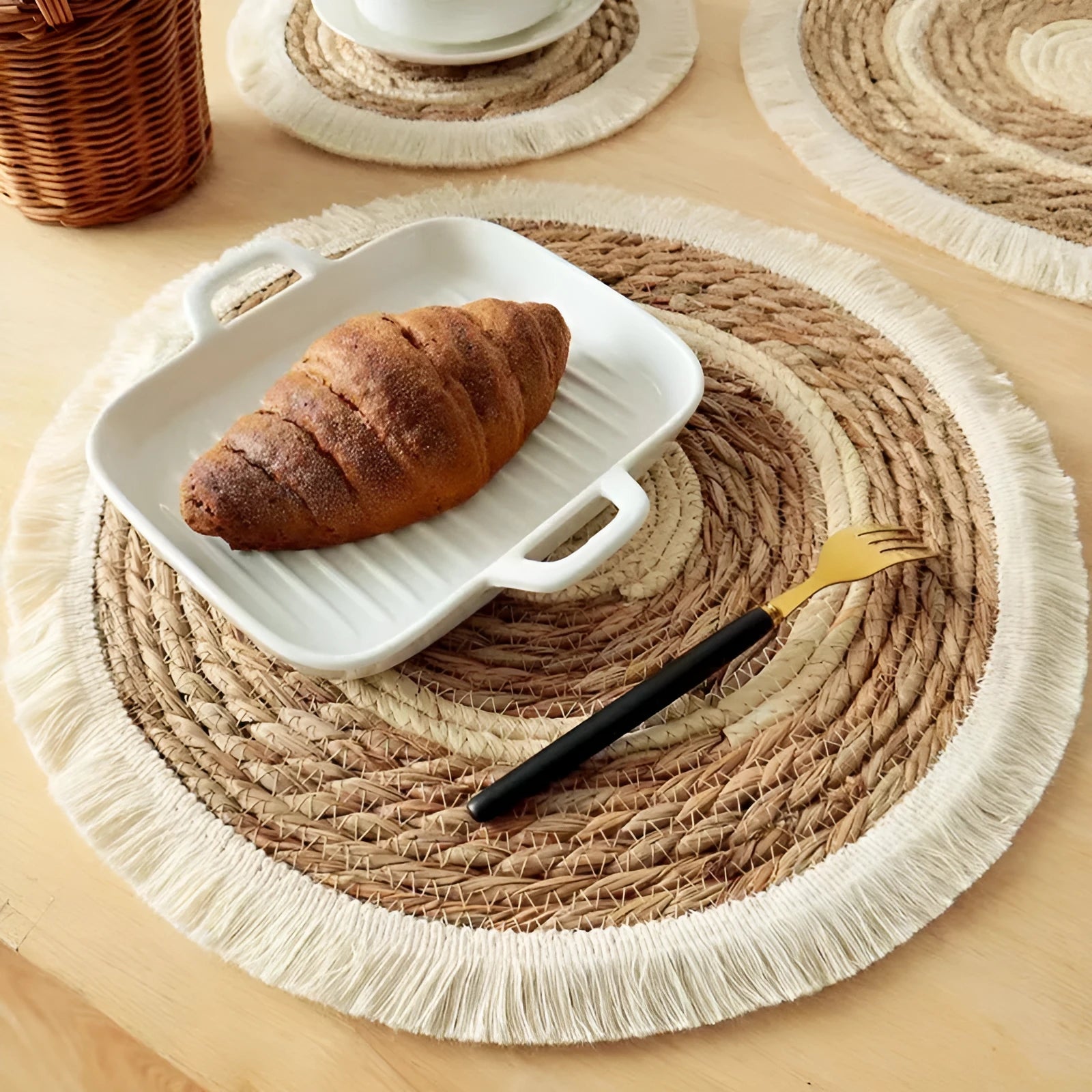 Japanese straw round placemat with tassel trim in natural papyrus material on dining table
