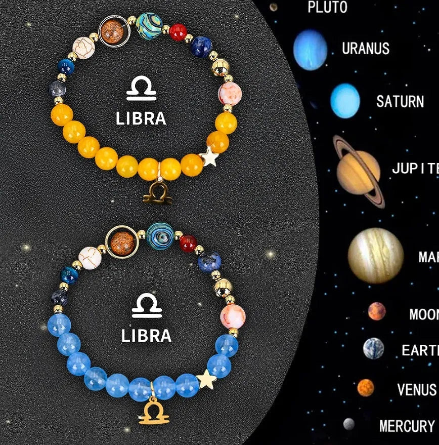 Two natural stone beaded bracelets with zodiac sign charms on a wooden surface