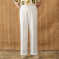 A pair of loose-fit, high-waisted linen trousers in a neutral colour with an elasticated waistband and straight legs.