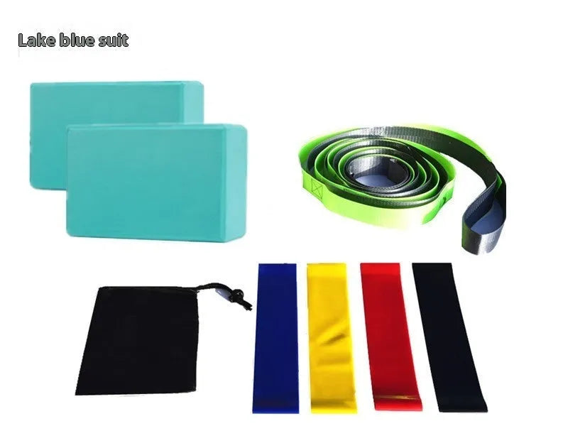 Yoga block eight-piece set with bricks, stretch belt, latex bands, and black storage bag on a floor.