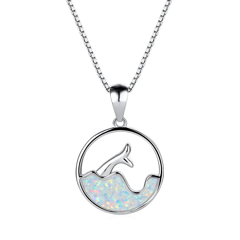Close-up of a white gold plated sea fishtail pendant necklace with a round blue opal stone.