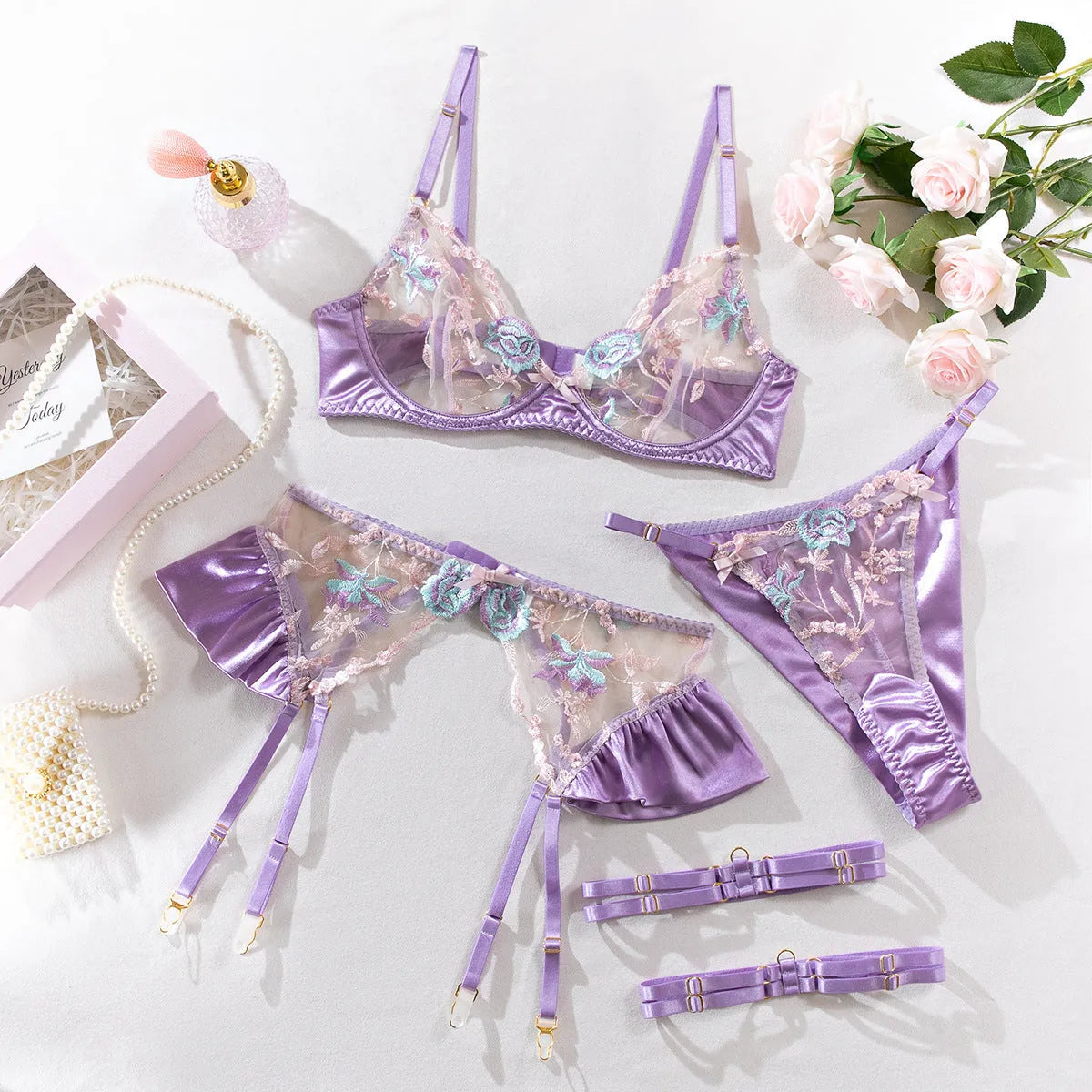 Light purple satin four-piece lingerie set with embroidery detail.