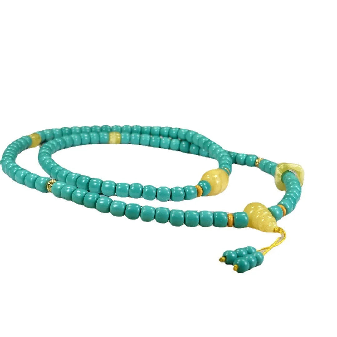 Turquoise lucky pendant necklace with hand-woven mesh flower design on a ball bead chain.