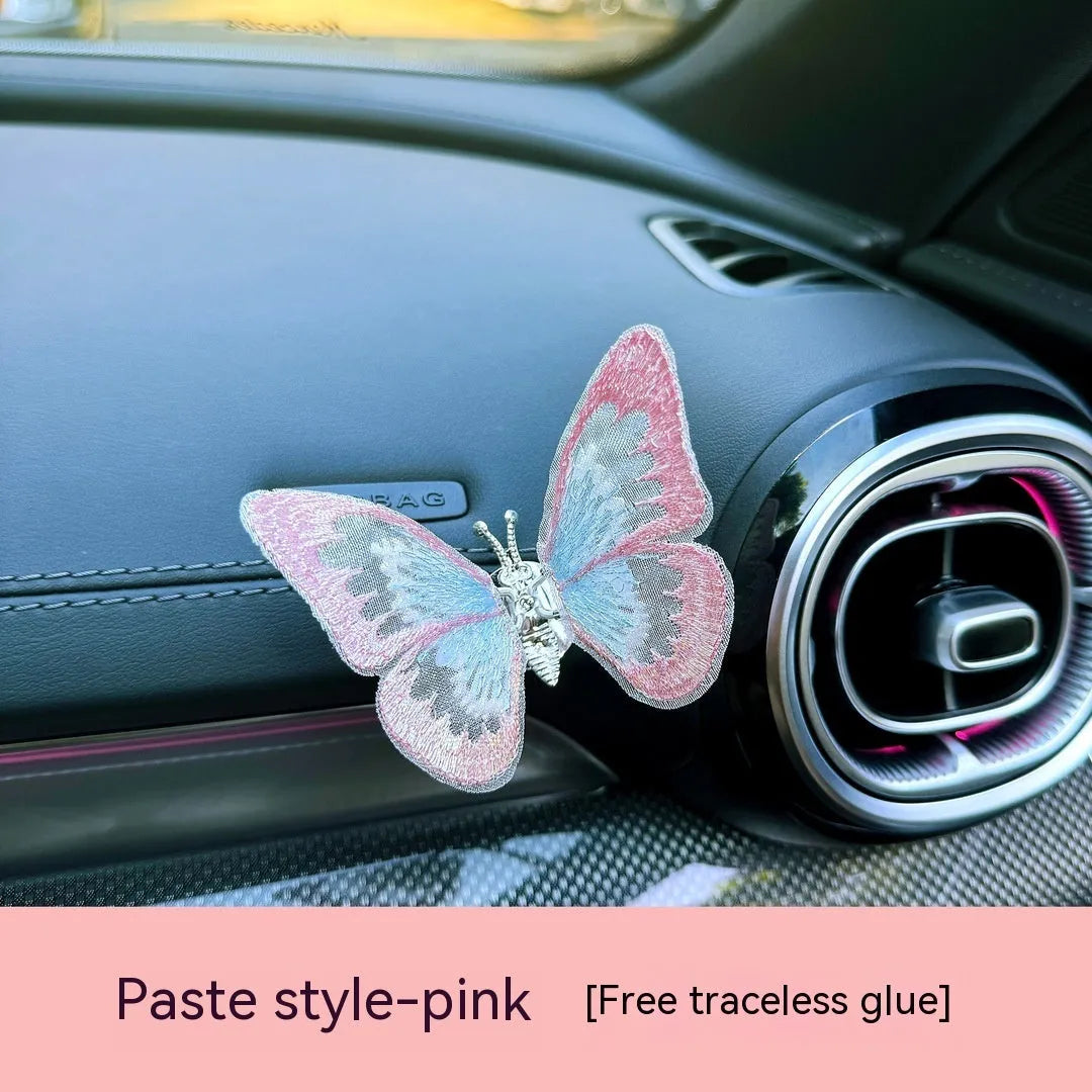 Moving embroidery butterfly decoration on car centre console air vent in pink fabric