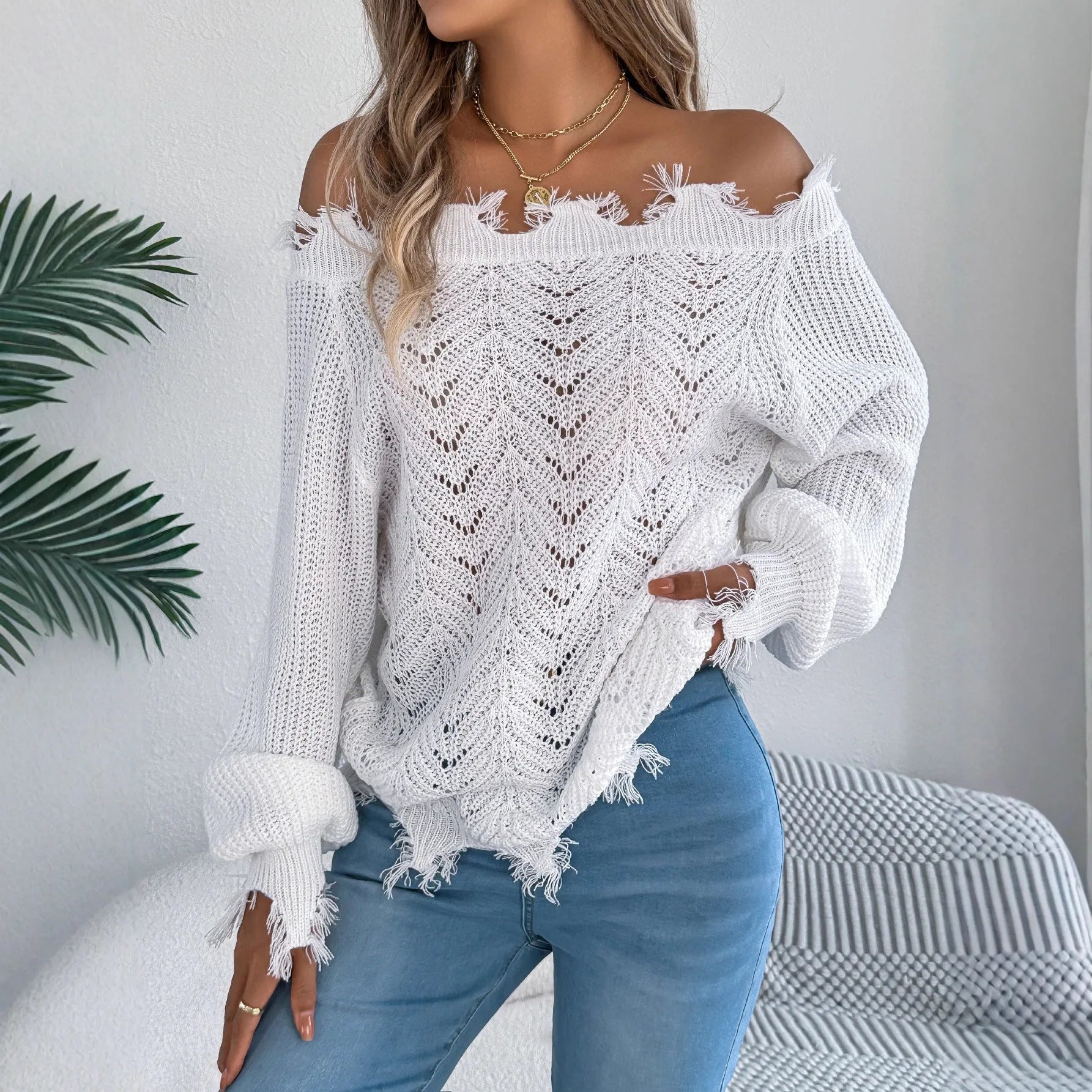 White hollow-out cut off shoulder pullover sweater with long sleeves on hanger