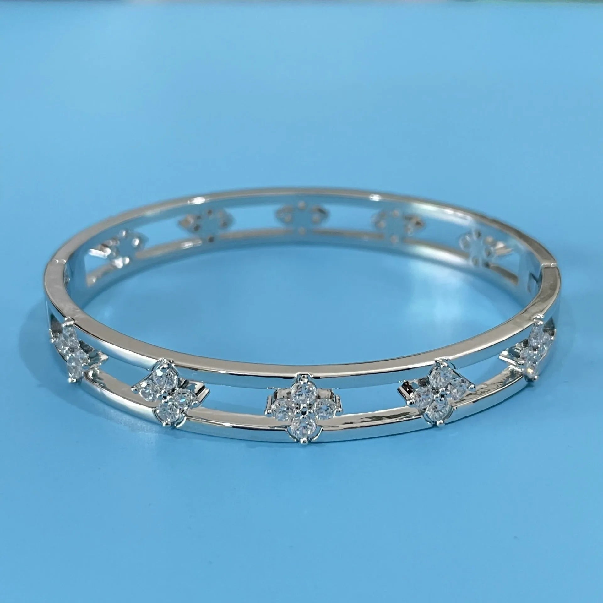 Gold or silver hollow women's bracelet with a four-leaf clover charm containing a white zircon stone.