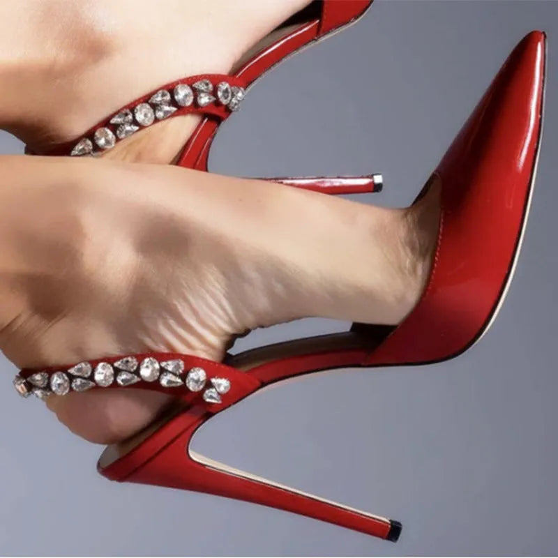 Rhinestone embellished pointed toe high heel sandals in glossy patent leather.