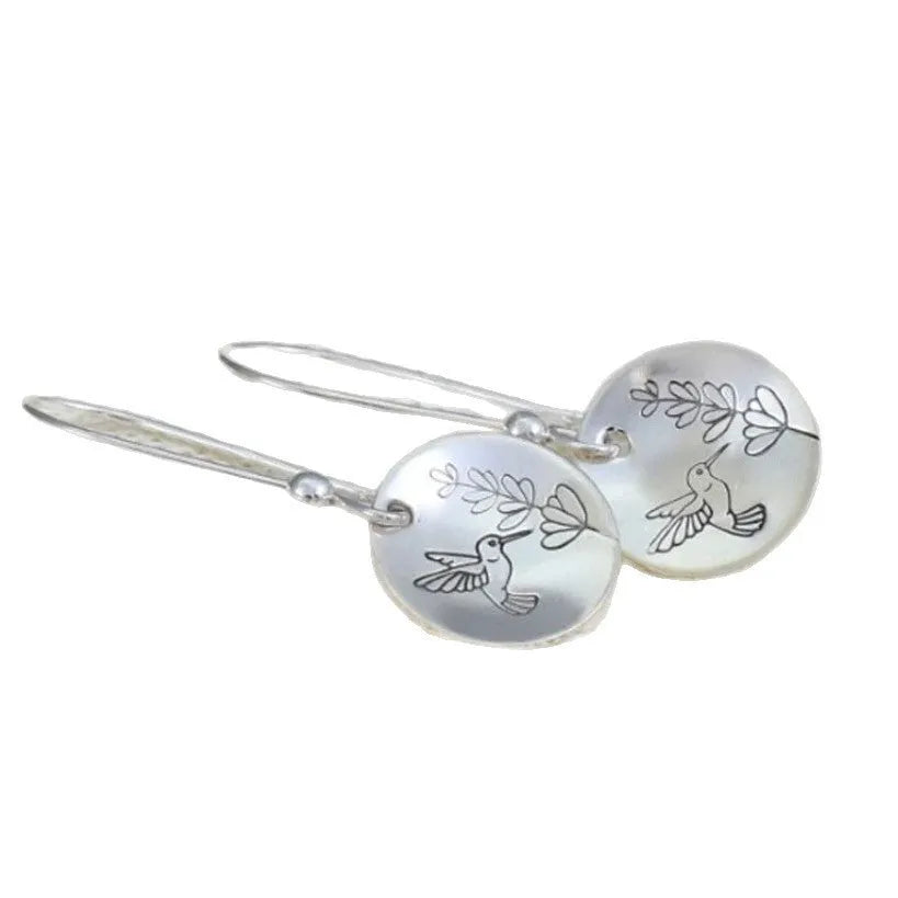Women's round silver earrings with glossy finish showing bird and flower retro designs