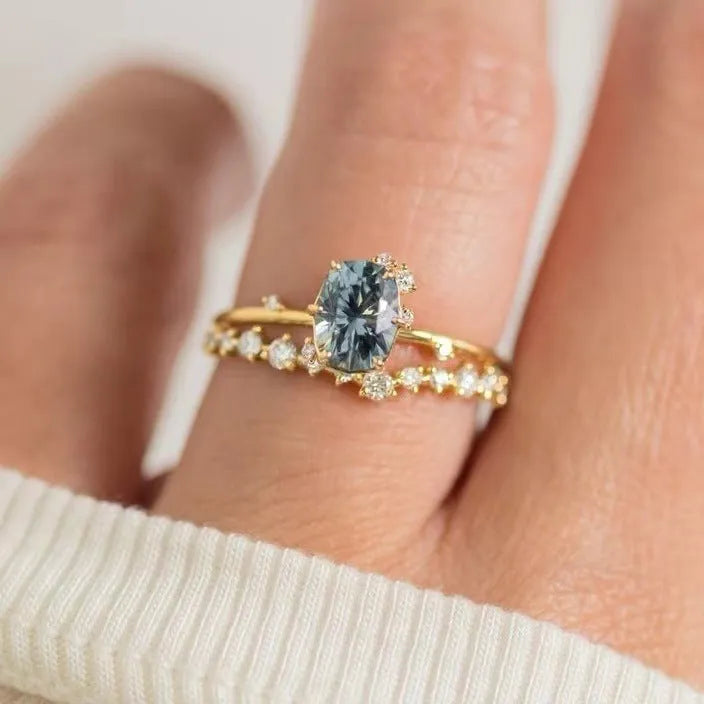 Gold plated women's ring with green zircon stone in floral design on a model's finger.