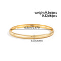 Exaggerated wide round glossy metal bracelet in gold tone on plain background