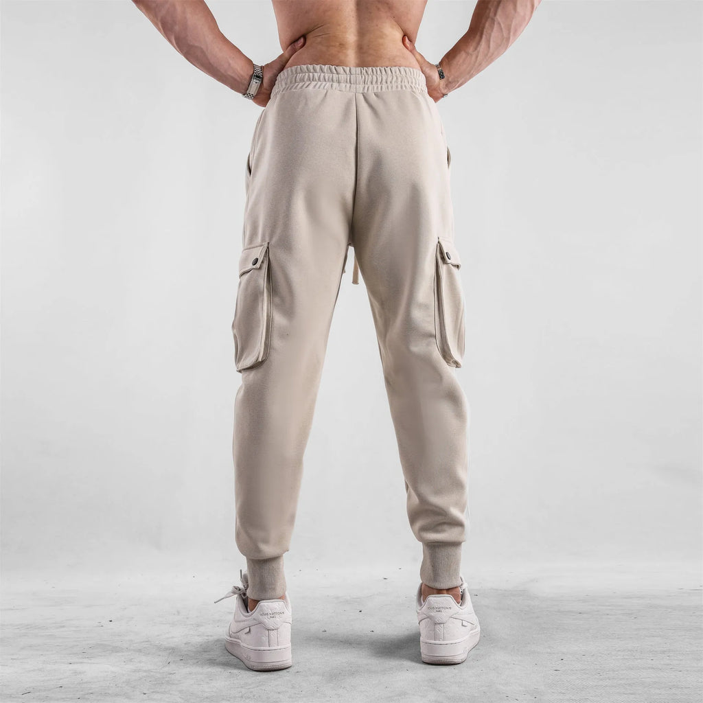 Men's loose-fit light grey cotton sports trousers with ankle tie and side pockets.