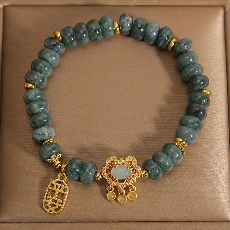 Close-up of a women's bracelet with emerald green jade abacus beads and a metallic safety lock clasp.