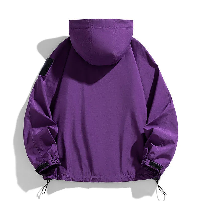 Man wearing a black hooded windproof waterproof jacket with long sleeves.