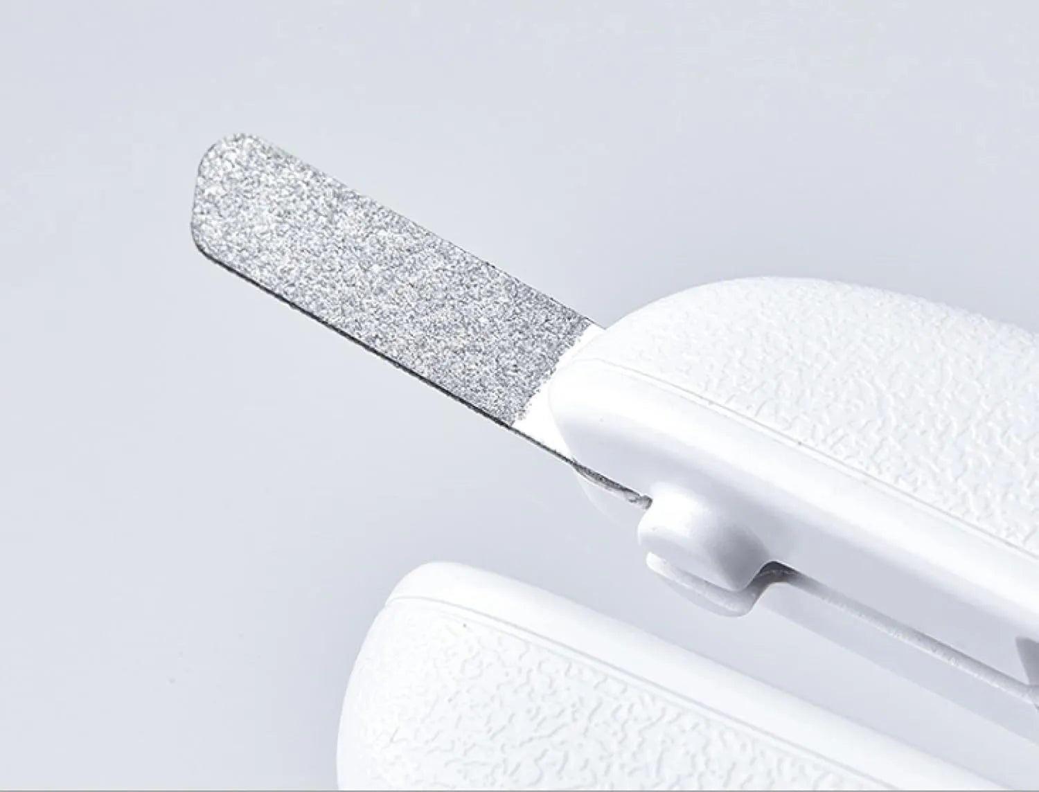 White pet nail clippers with LED light and a transparent anti-splash guard, shown with a nail file.