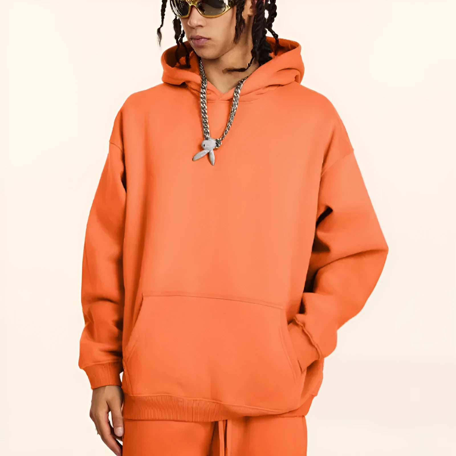 Man wearing a loose-fit grey terry cotton hooded sweater with drop-shoulder sleeves.