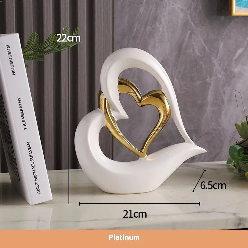 Modern white porcelain heart ornament in a metallic finish, showing its geometric shape on a table.