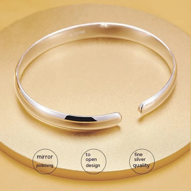 Glossy silver-plated copper bracelet with Ruyi and lucky cat charms on white background