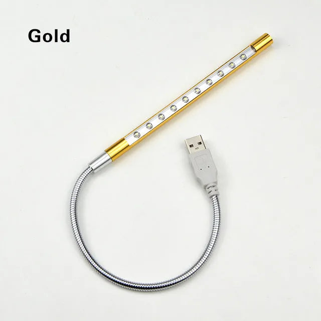 Black aluminium alloy spiral USB LED night light on a desk next to a laptop