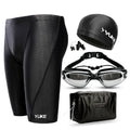 Men's black five-piece swimming set including trunks, goggles, cap, ear plugs, nose clip, and carry bag laid out flat.